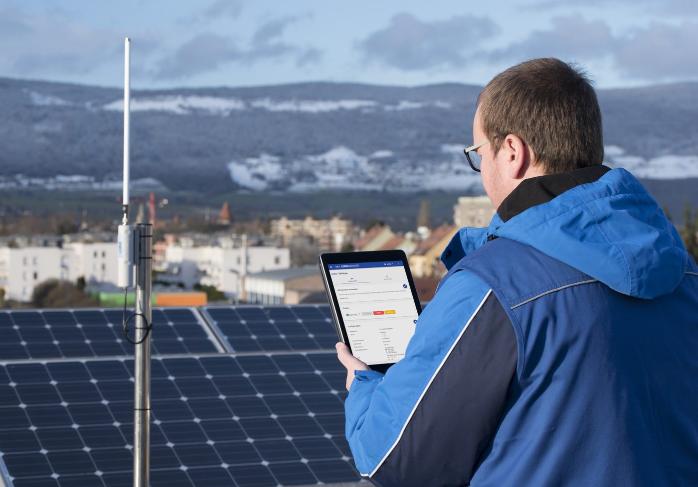 WIFX L1 4G pole-mounted at a solar-powered field site, technician checking the LORIX Manager interface on a tablet